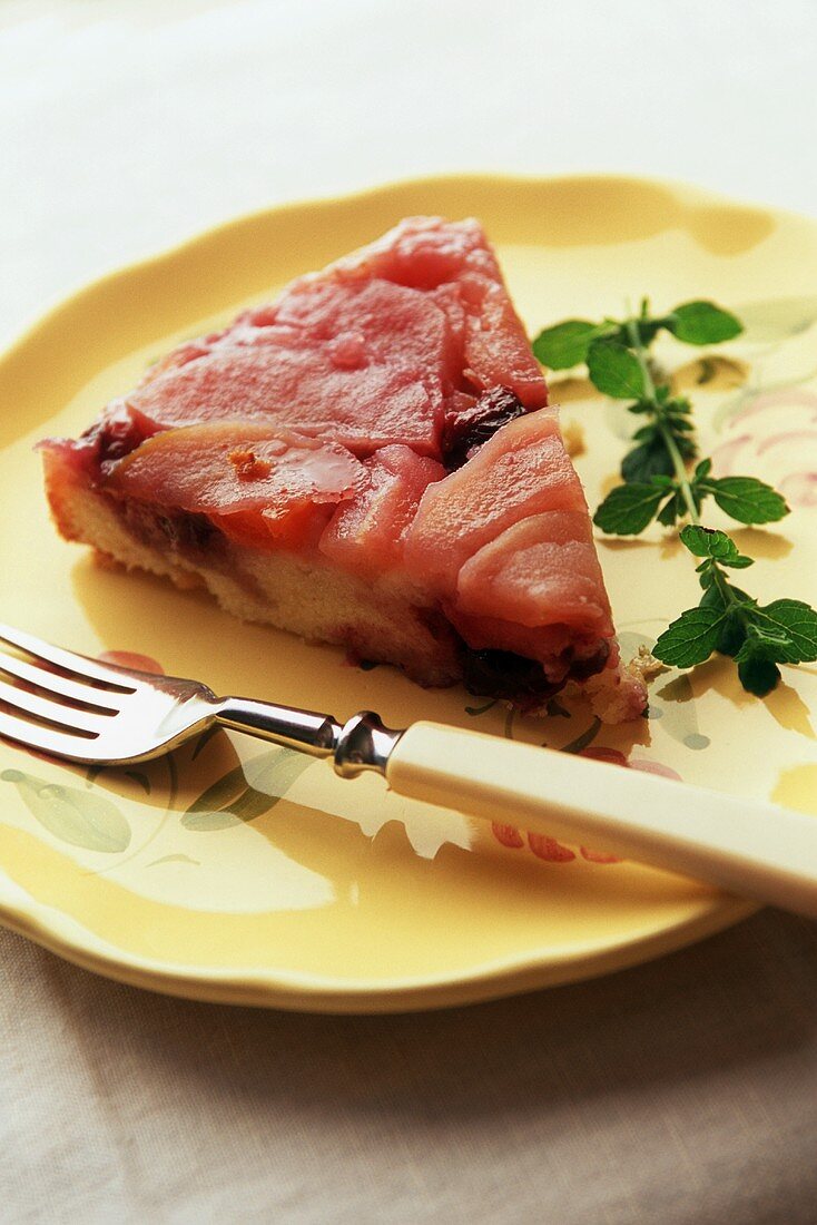 Slice of Apple Upside Down Cake on a Yellow Plate with a Fork