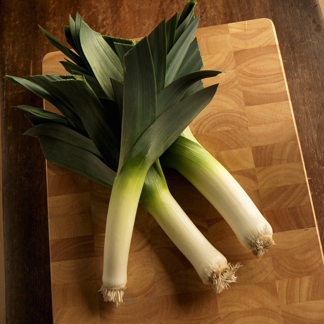 Three Leeks on a Cutting Board