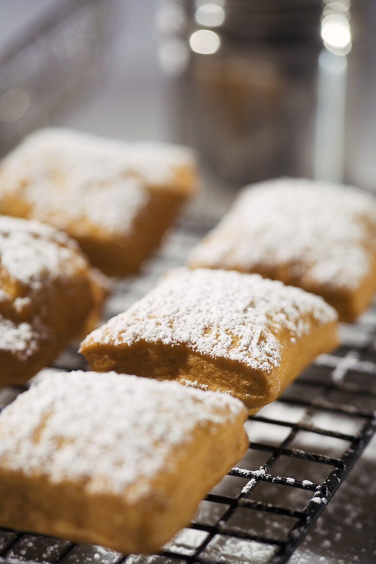 Beignets Topped with Powdered Sugar on a Cooling Rack