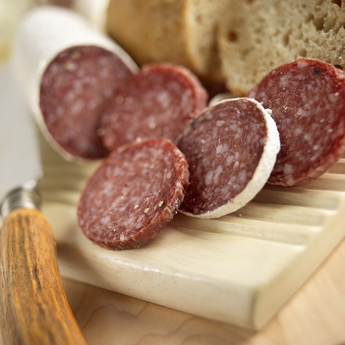 Italienische Salami in Scheiben und Weißbrot auf einem Brotzeitbrett