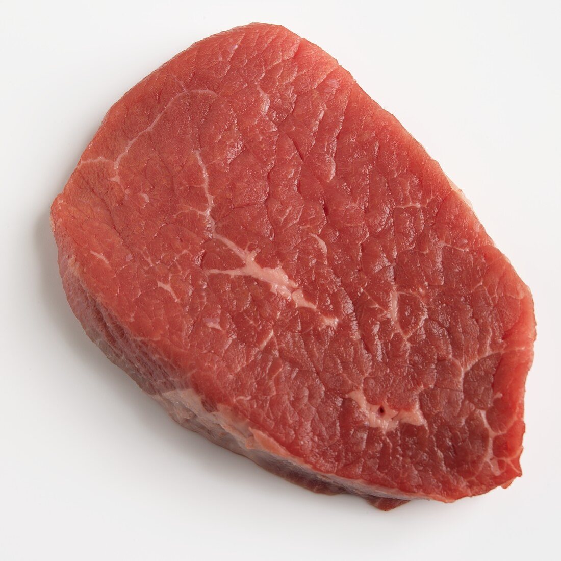 A beef steak on a white surface
