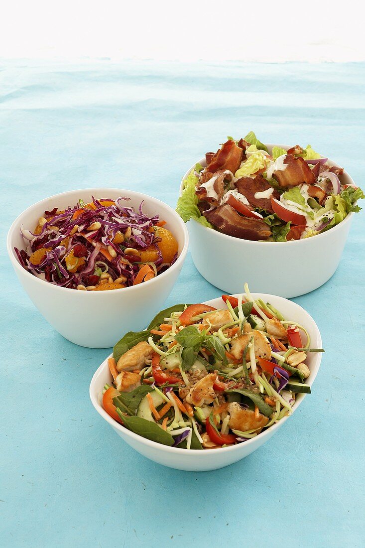 Three different vegetable salads in white dishes