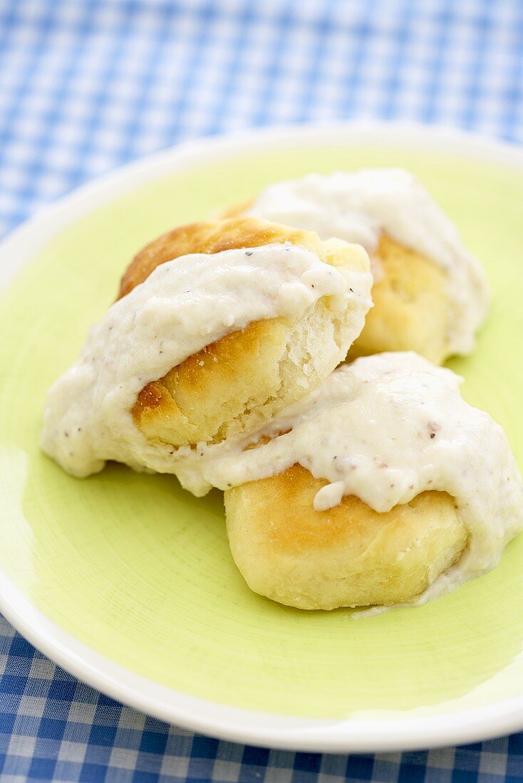 Biscuits Topped with White Gravy on a Yellow Plate