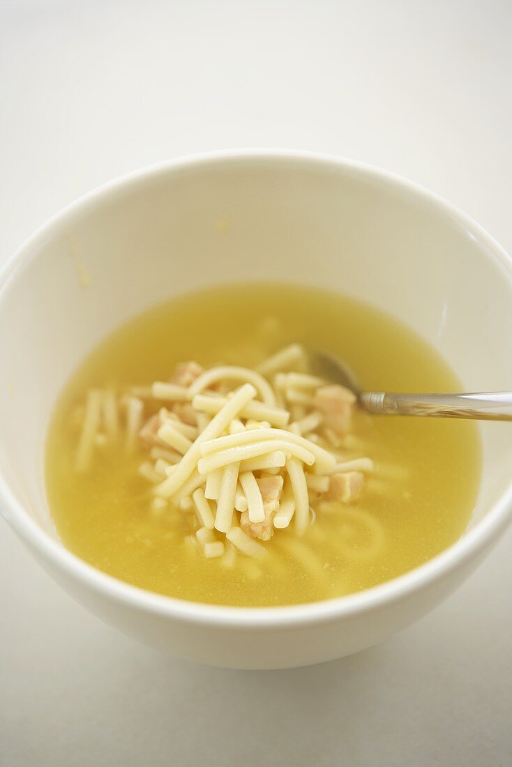 Hühnersuppe mit Nudeln in weißem Schälchen