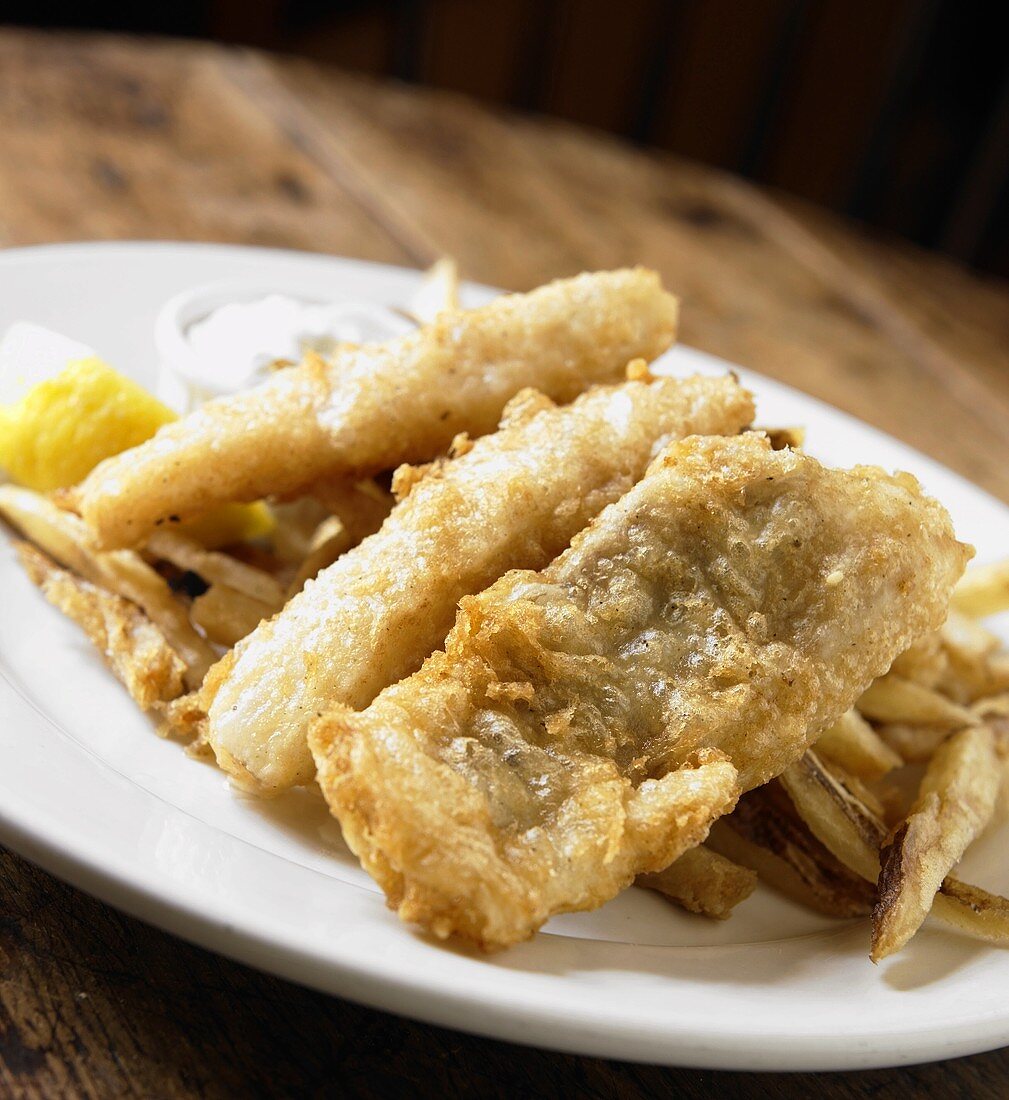 Teller mit Fish & Chips auf Holztisch