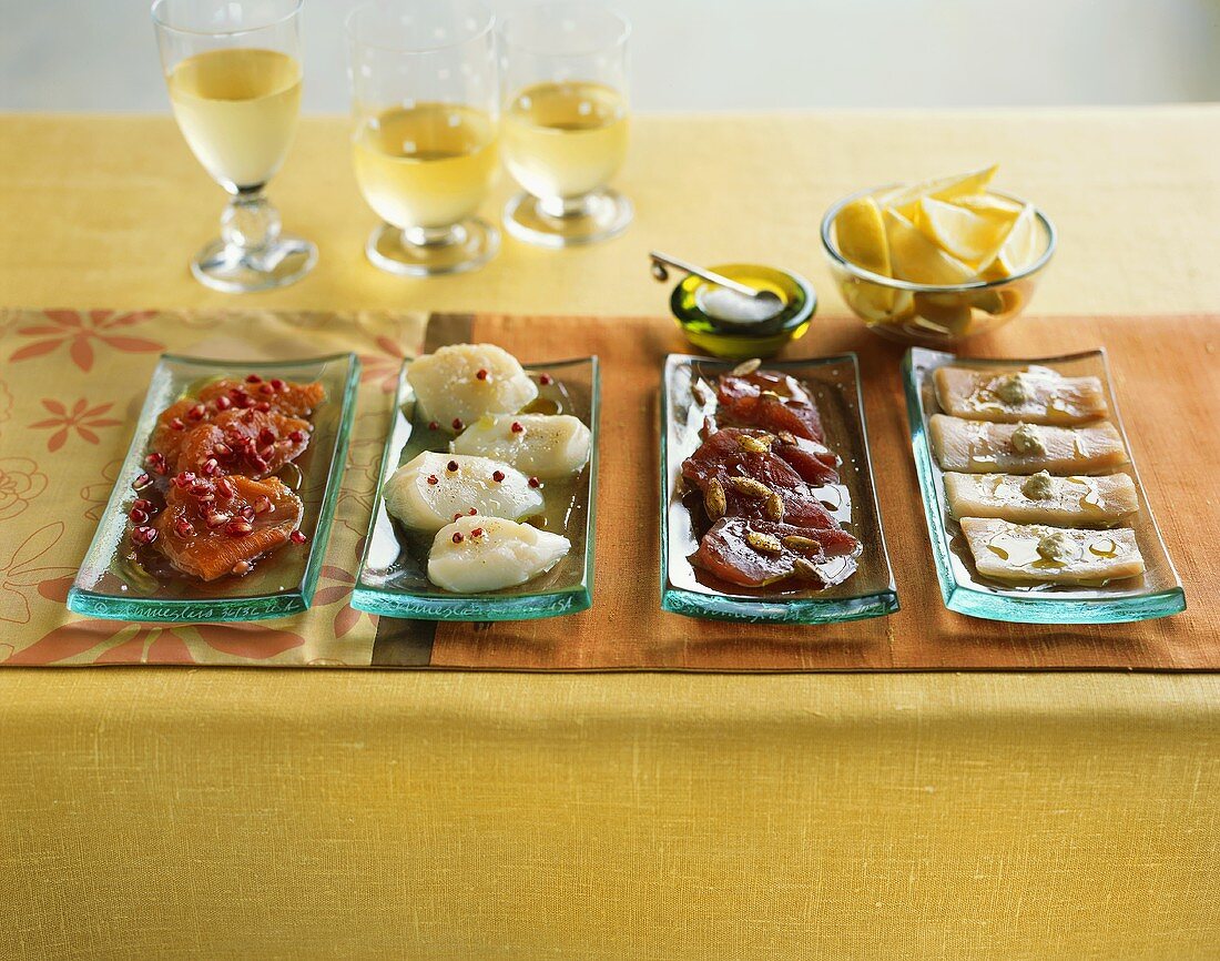 Vier Sashimiplatten mit Zitronen und Weißwein