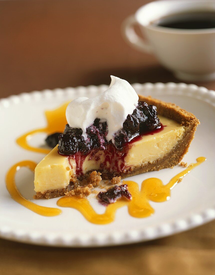 Stück Käsekuchen mit Beeren und Sahne, angebissen