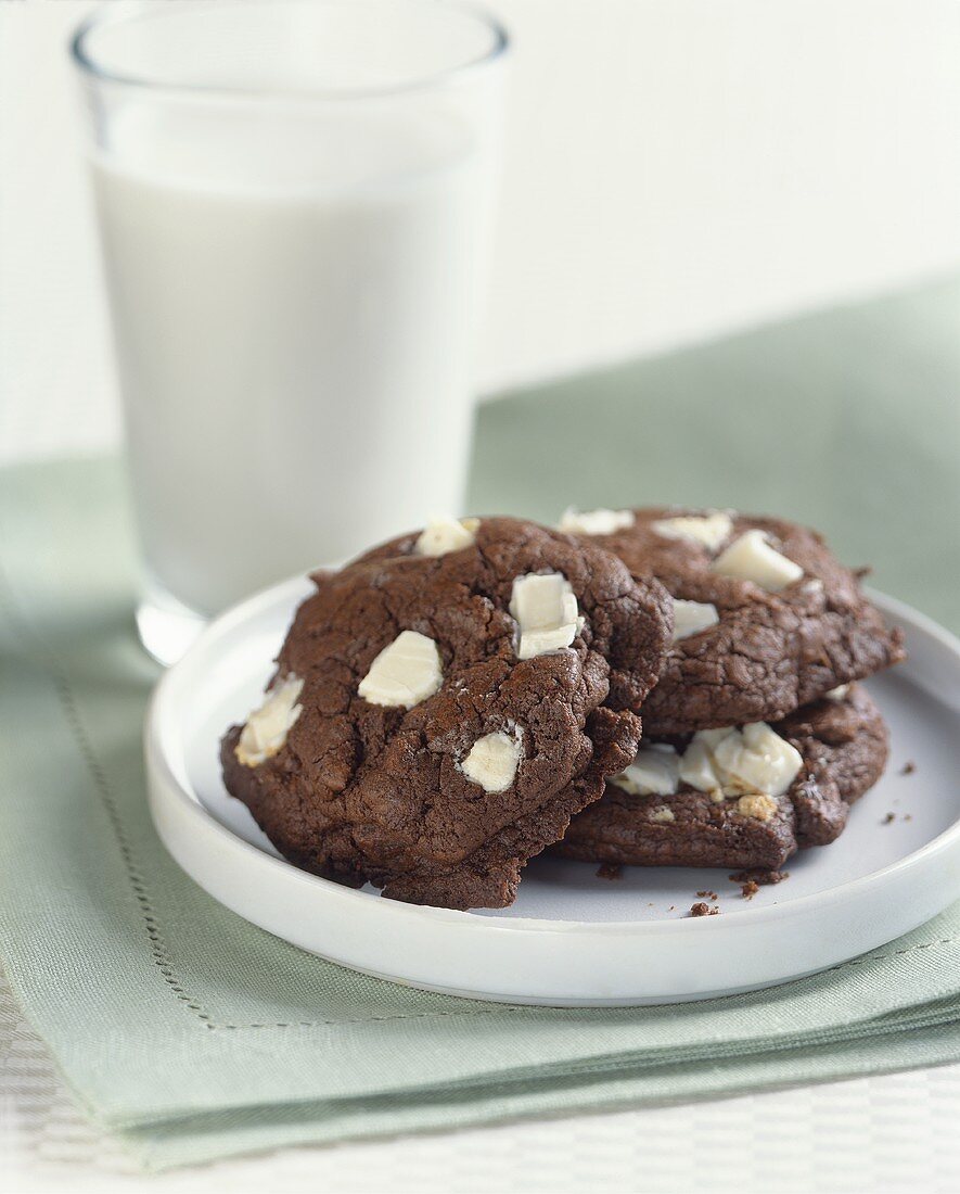 Chocolate White Chunk Cookies on a Plate with a Glass of Milk