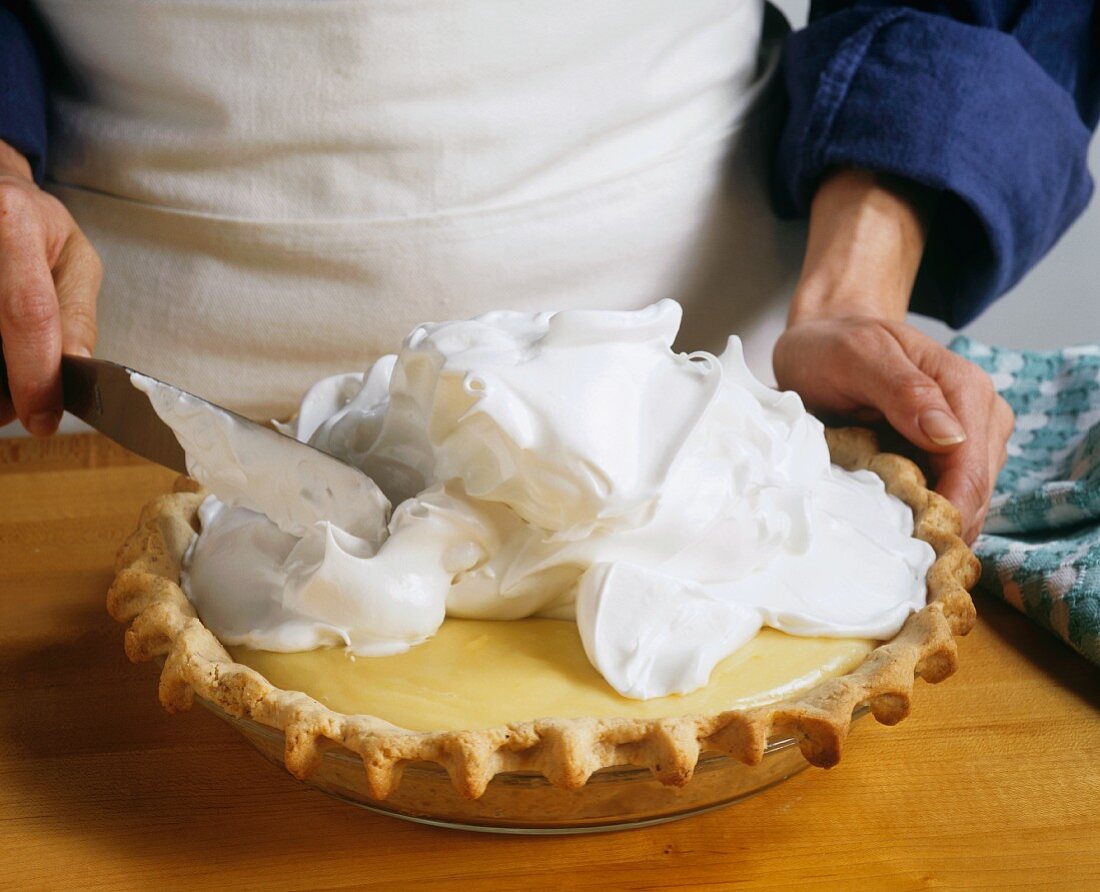 Baker Spreading Meringue On a Cream Pie