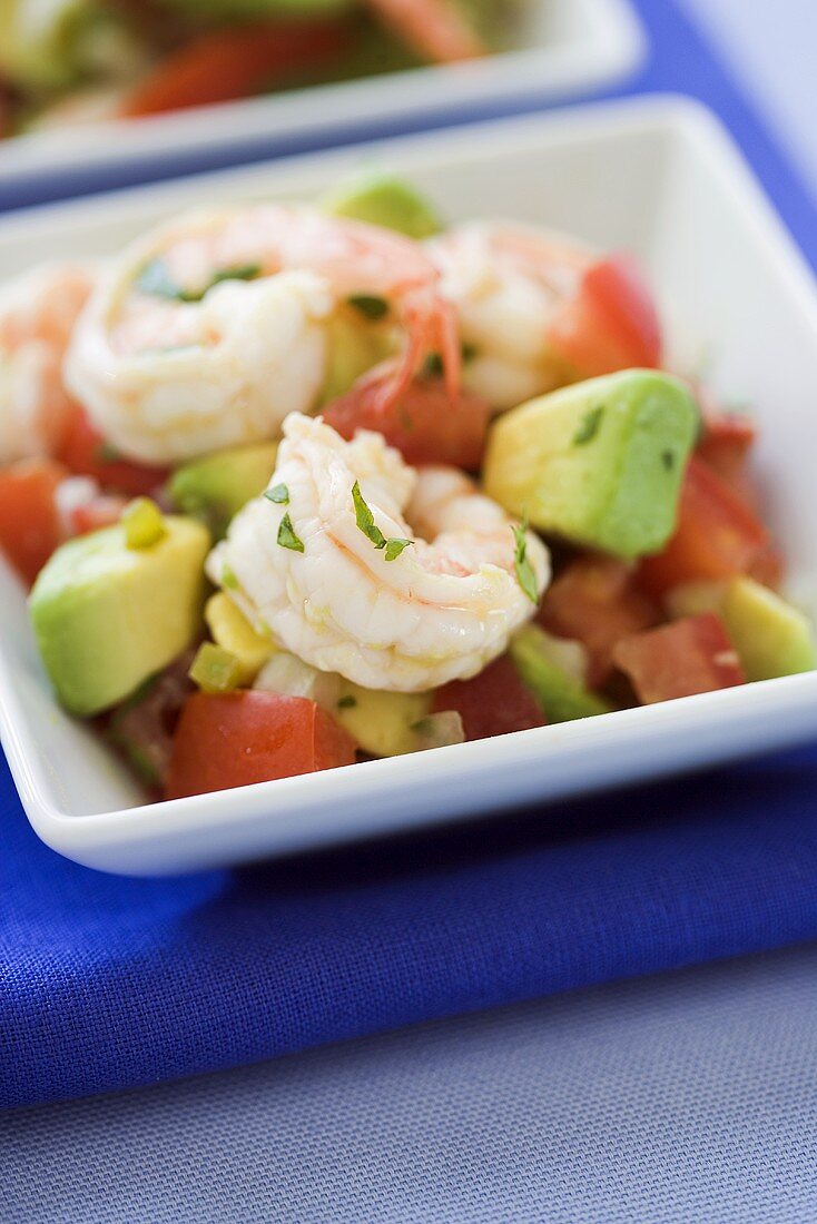 Ein Schälchen mit Avocado-Tomaten-Salat mit Shrimps