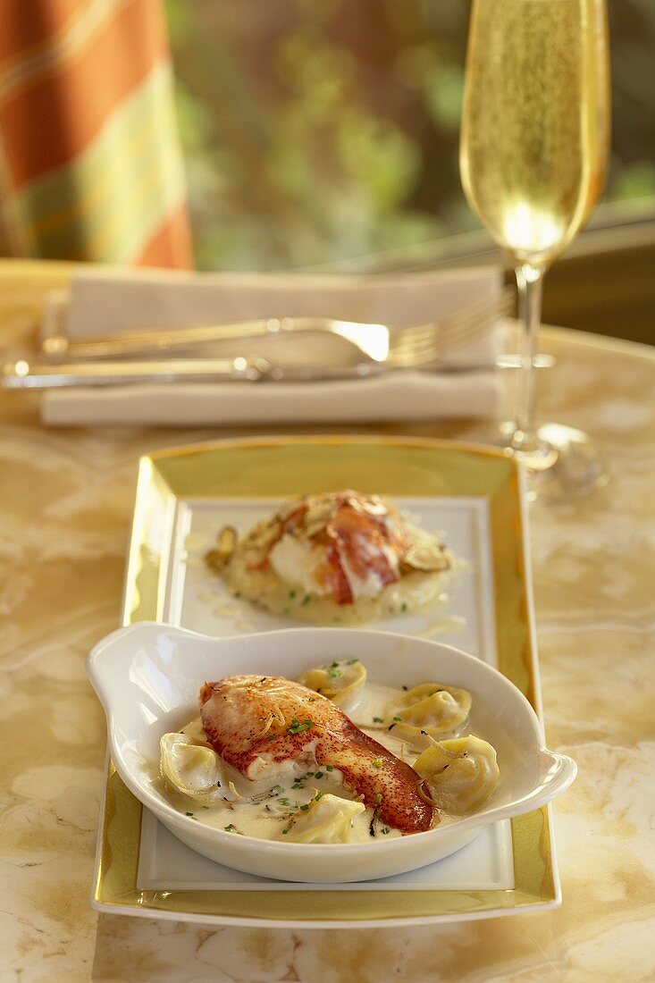 Lobster Tortellini in a White Dish; Glass of Champagne