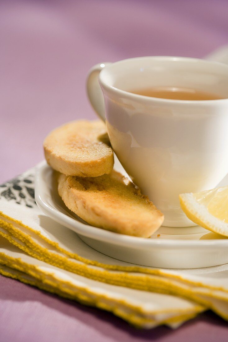 Eine Tasse Zitronentee mit Biscotti