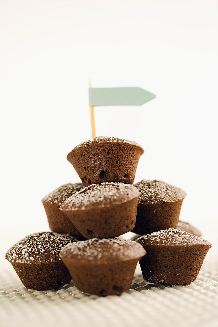 Gestapelte Mini-Schokoladen-Muffins mit einem Papierfähnchen