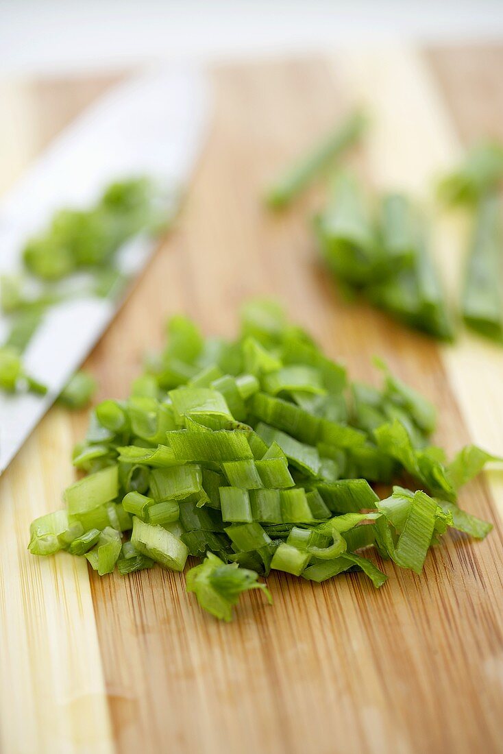 Tops of Green Onions Chopped on a Cutting Board, Knife