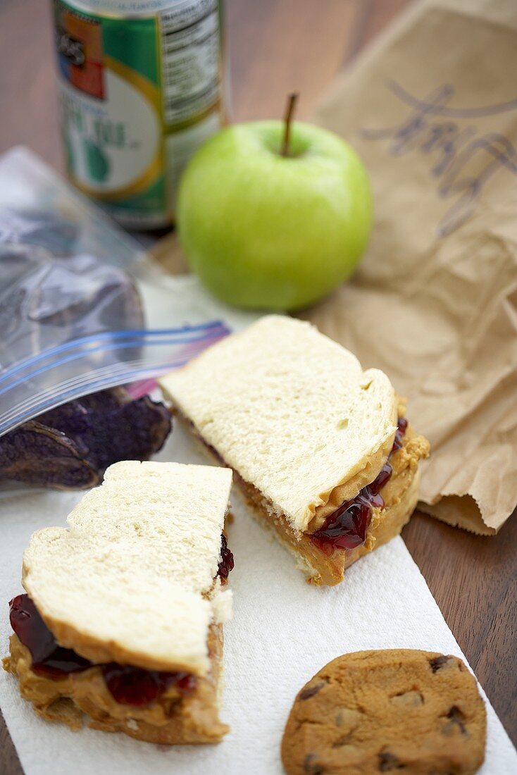 Peanutbutter-Jelly-Sandwich, Keks, Apfel und Lunchtüte