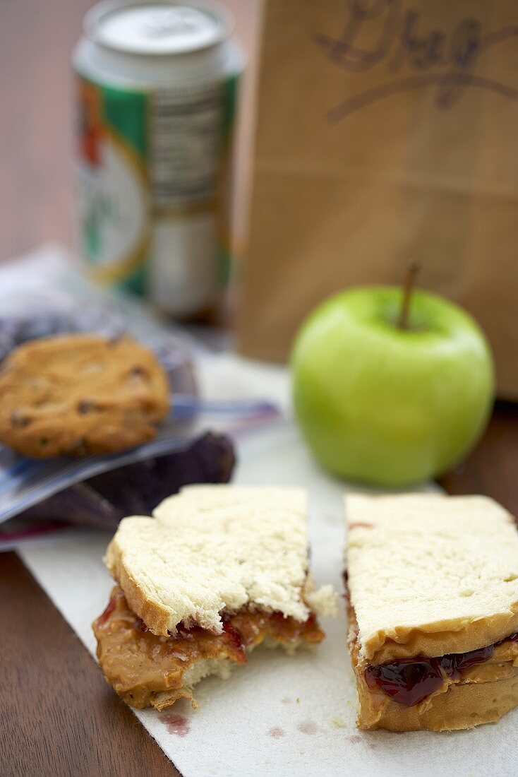 Peanutbutter-Jelly-Sandwich, ein Apfel und Lunchtüte