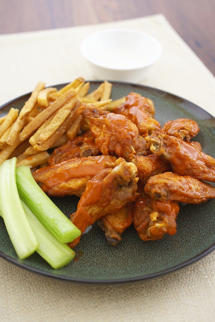 Buffalo Wings on a Plate with Celery Sticks and French Fries