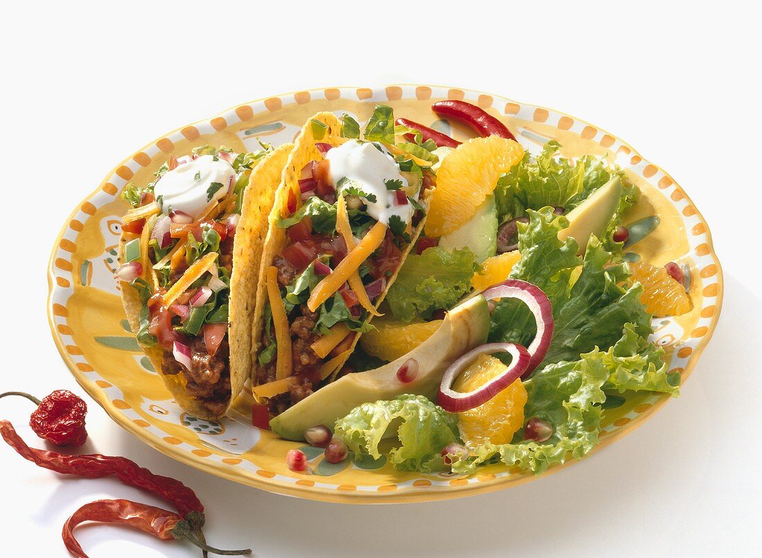 Two Tacos on a Plate with Citrus Avocado Salad, White Background