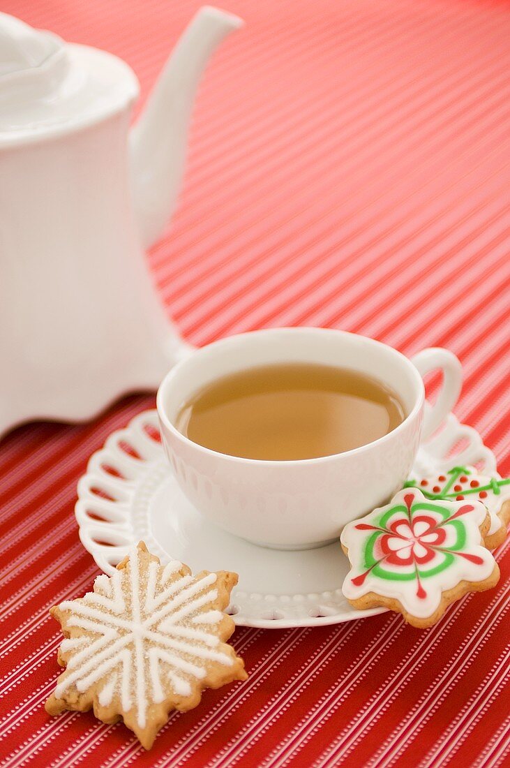 Eine Tasse Tee mit verzierten Weihnachtsplätzchen