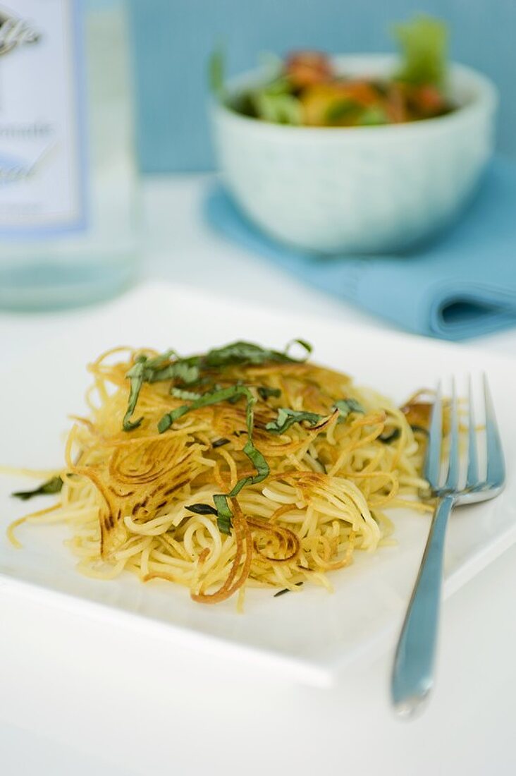 Baked Spaghetti on a Plate Topped with Basil Ribbons