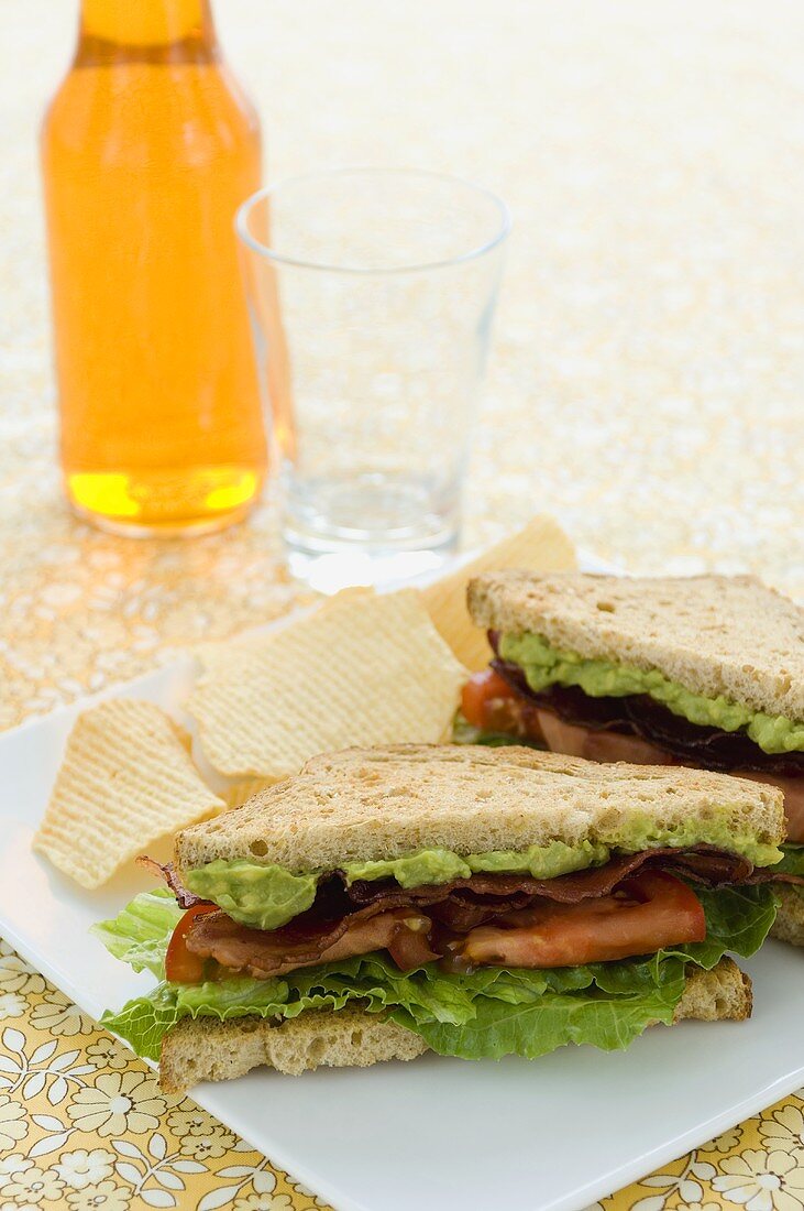 BLT-Sandwich mit Guacamole auf Teller mit Chips