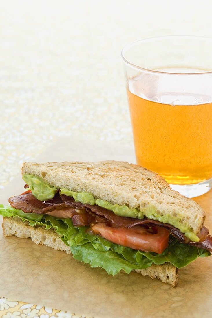 BLT-Sandwich mit Guacamole und ein Glas Bier