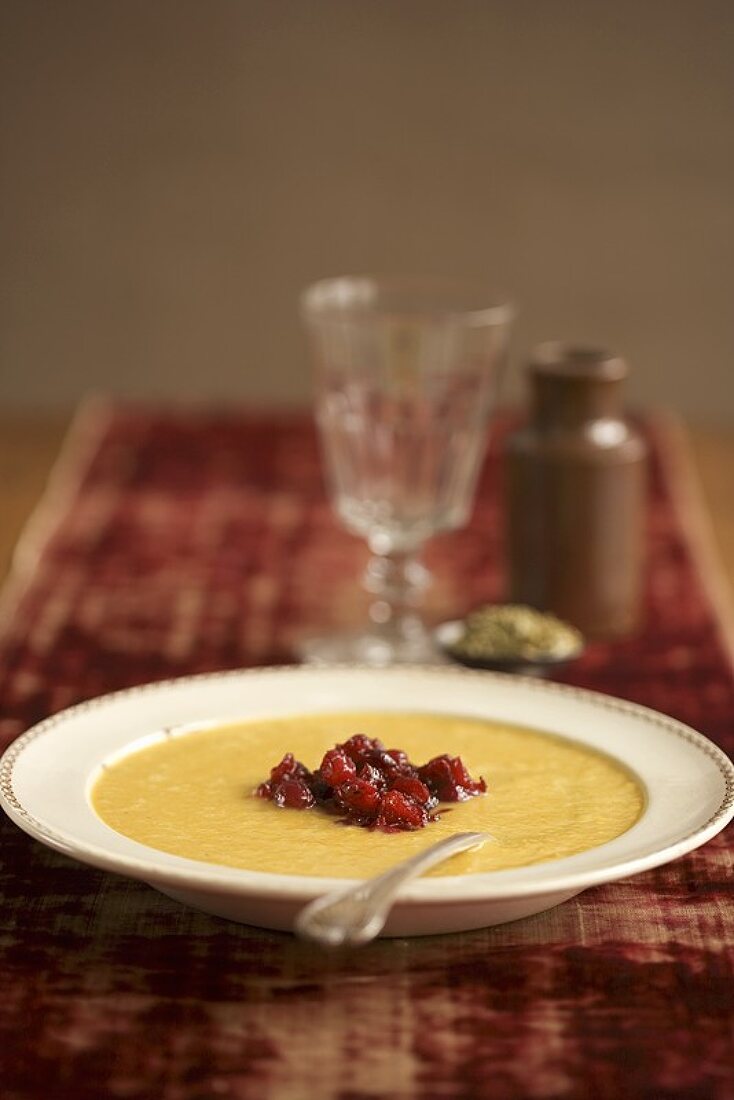 Bowl of Pumpkin Soup Topped with Chunky Cranberry Sauce