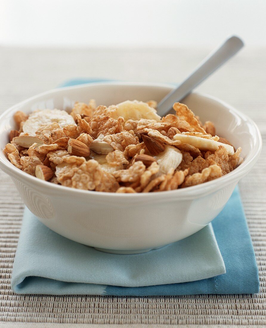Bowl of Almond and Wheat Flake Cereal with Banana Slices; Spoon