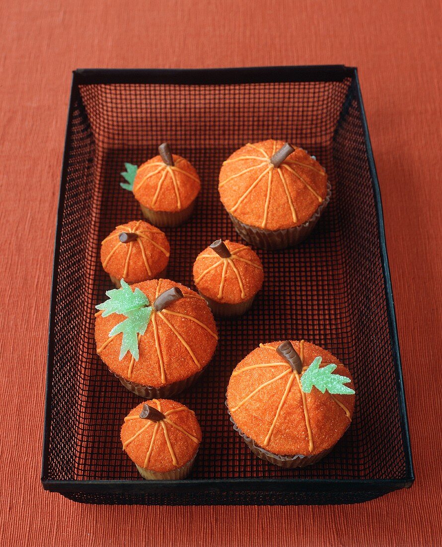 Verzierte Kürbis-Cupcakes im Drahtkorb für Halloween