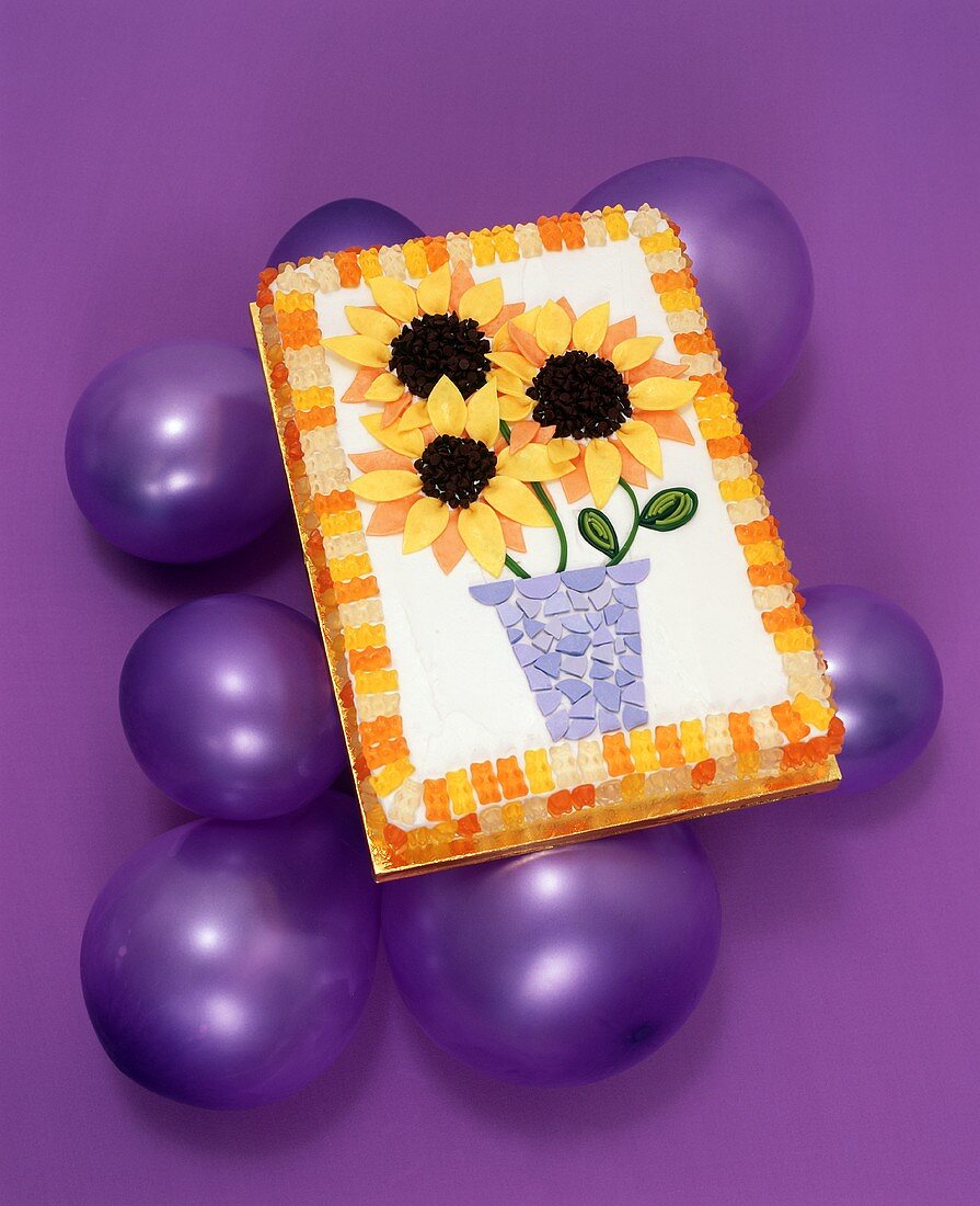 Sonnenblumentorte auf violetten Luftballons