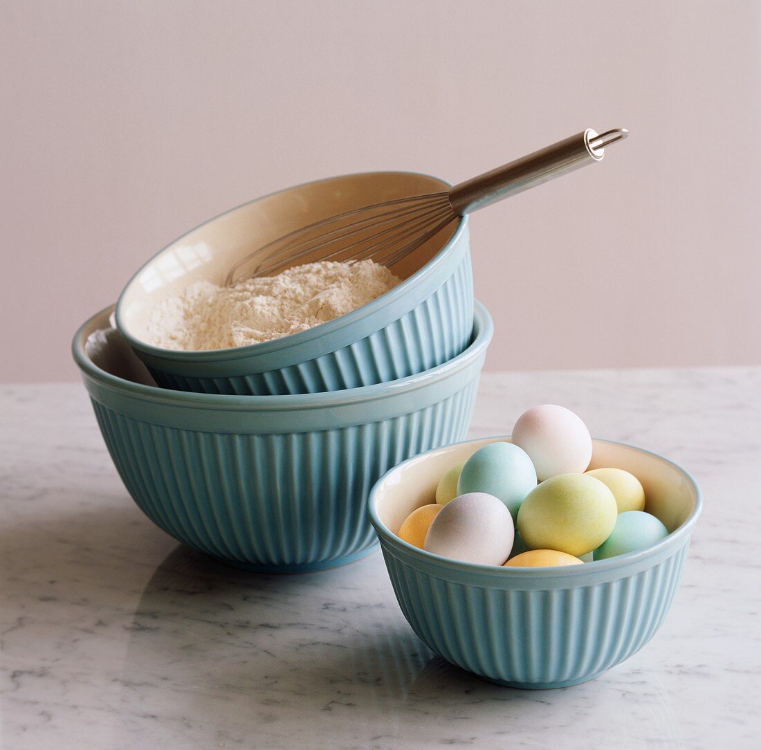 Three Blue Mixing Bowls; One with Colored Eggs, One with Flour