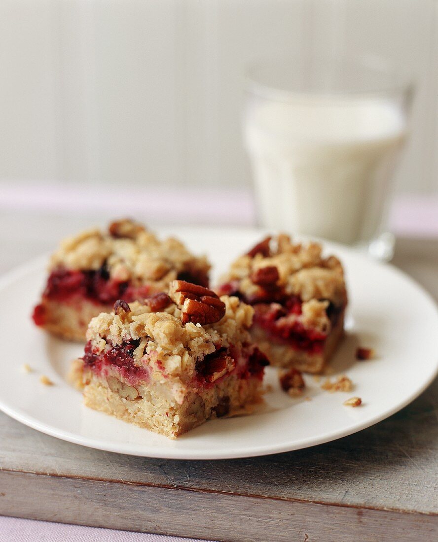 Three Pieces of Berry Crumble Cake on a Plate; Glass of Milk