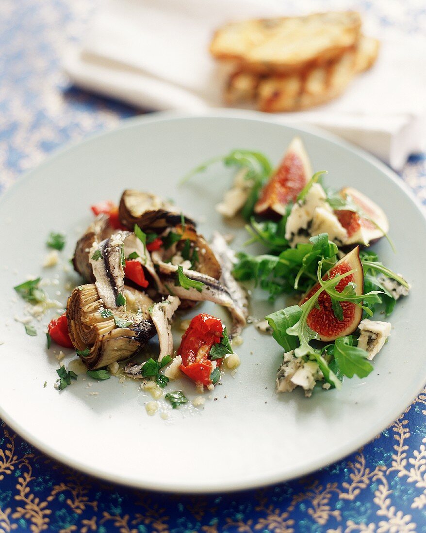 Artischockensalat und Feigen-Rucola-Salat auf Teller