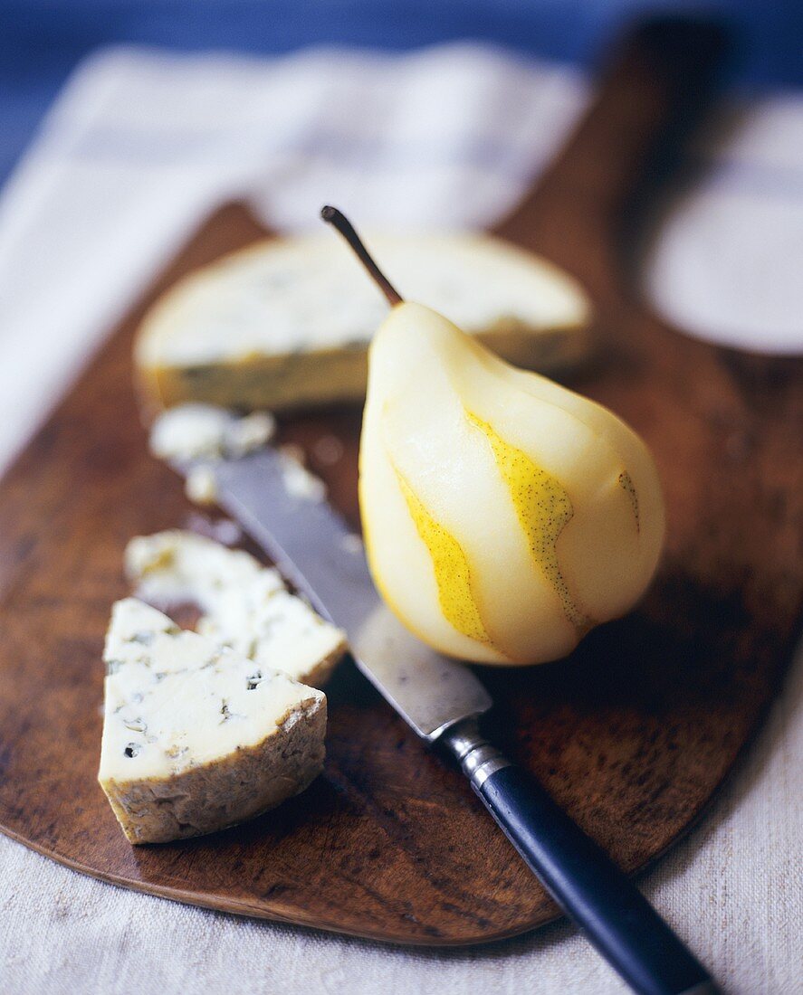 Fresh Partially Peeled Pear with Blue Cheese on a Board