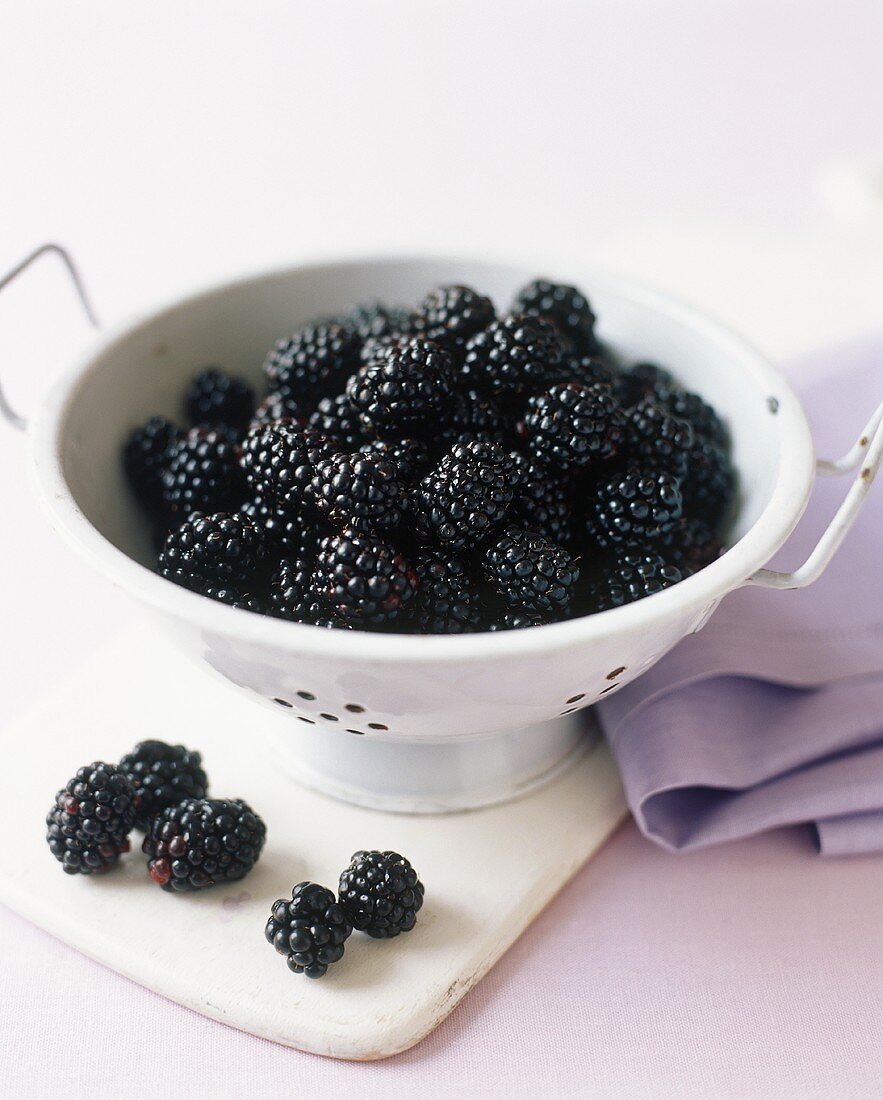 Fresh Blackberries in and Beside a Colander