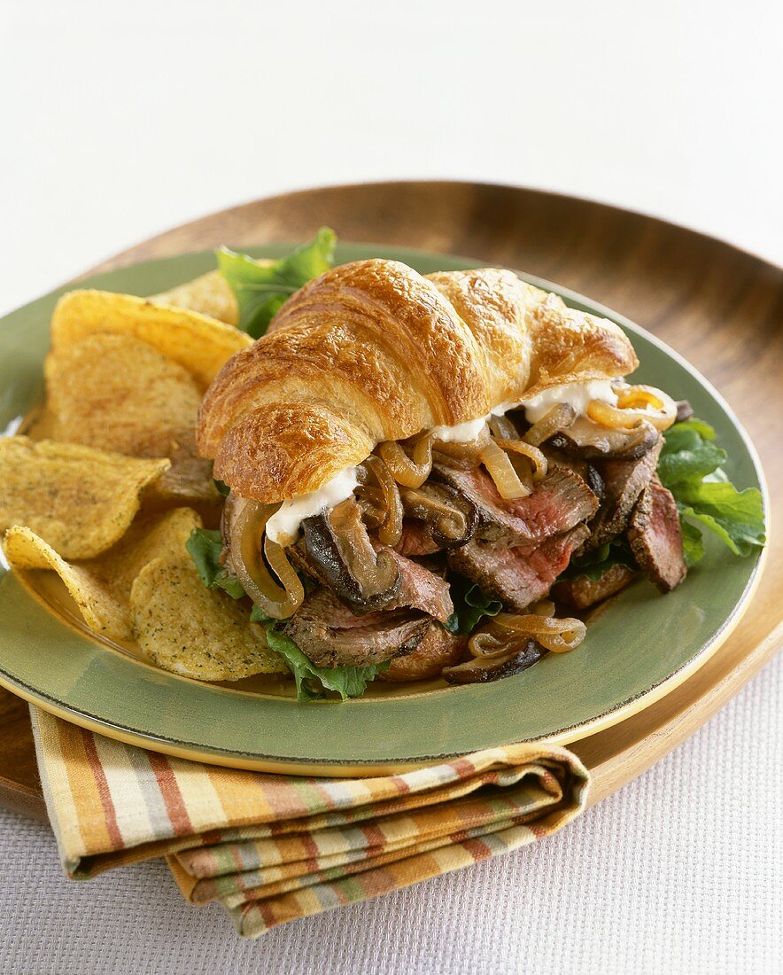 Rindersteak in Scheiben mit Pilzen, Zwiebeln in Croissant