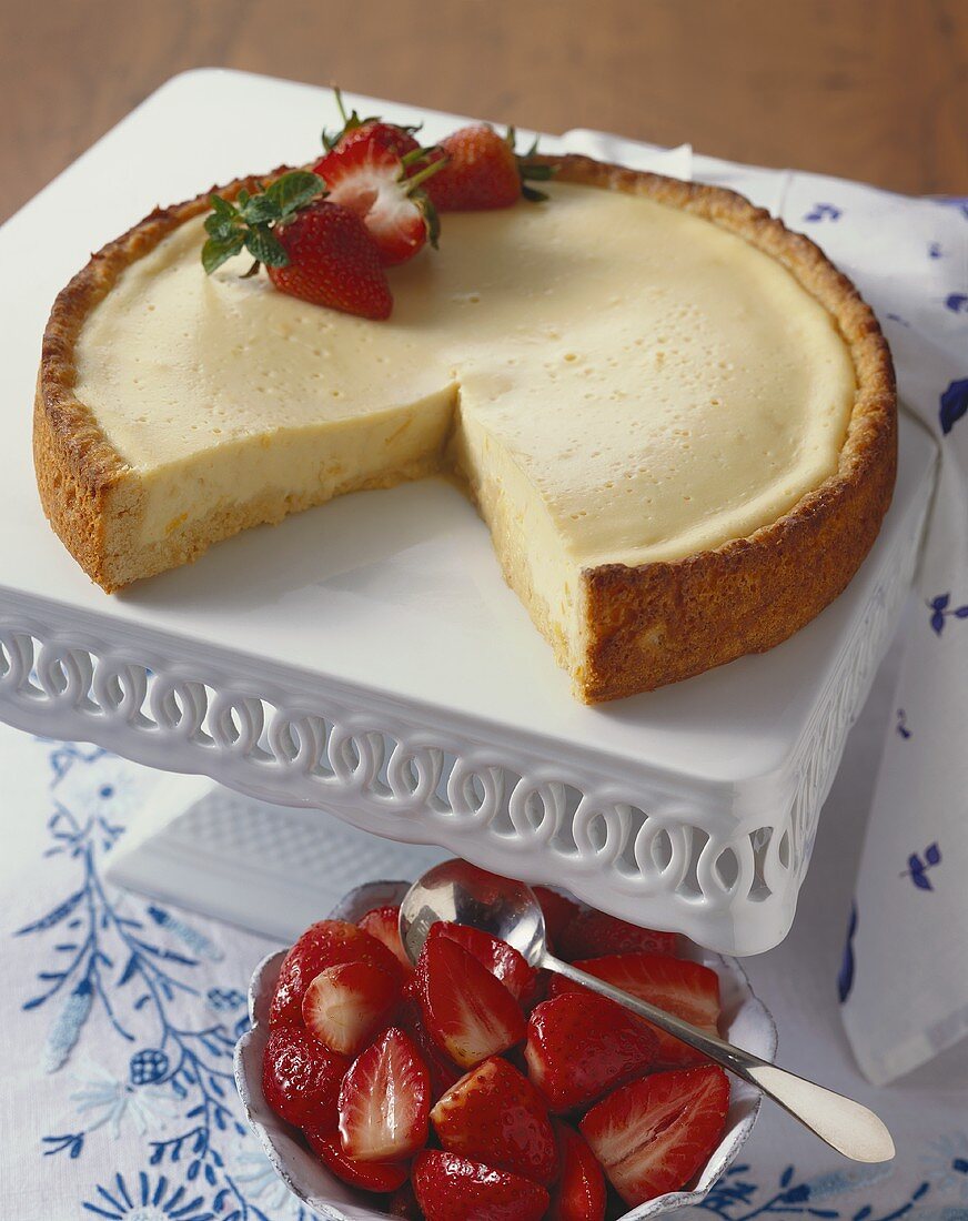 A Whole Cheesecake with Slice Removed and Strawberries