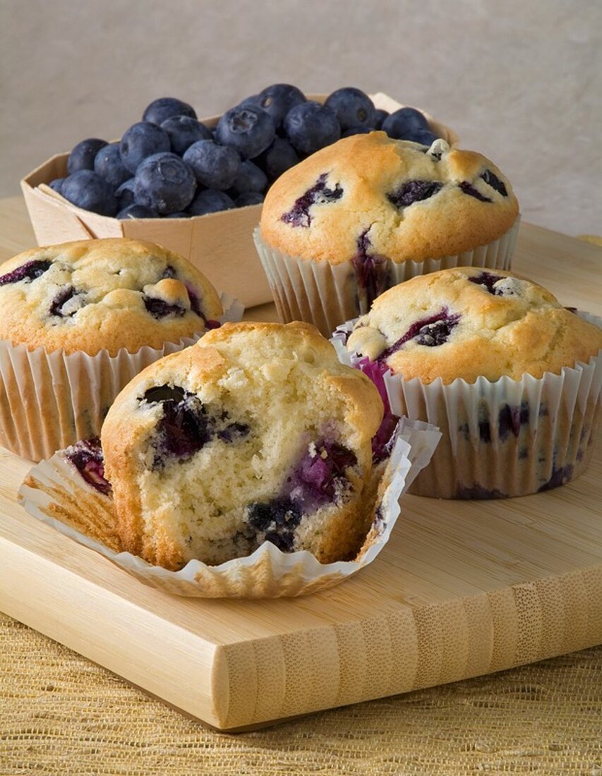 Frisch gebackene Heidelbeermuffins auf einem Holzbrett