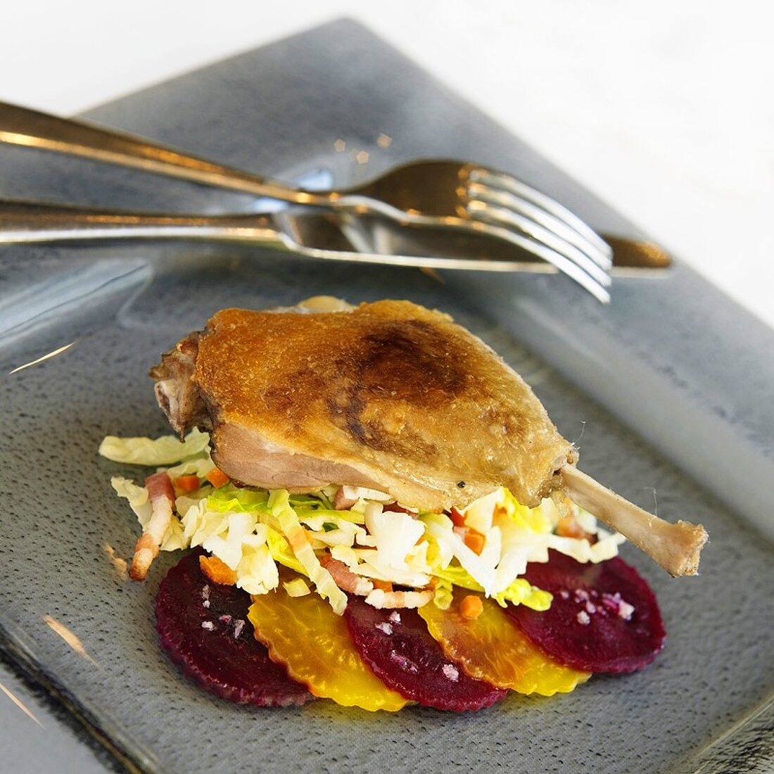 Duck Leg Over Coleslaw with Sliced Red and Yellow Beets