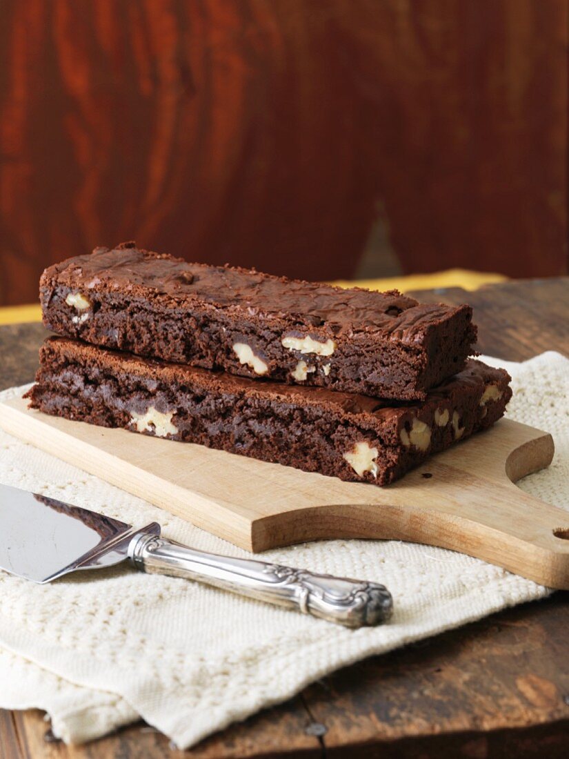 Zwei groosse Walnuss-Brownies auf einem Schneidebrett