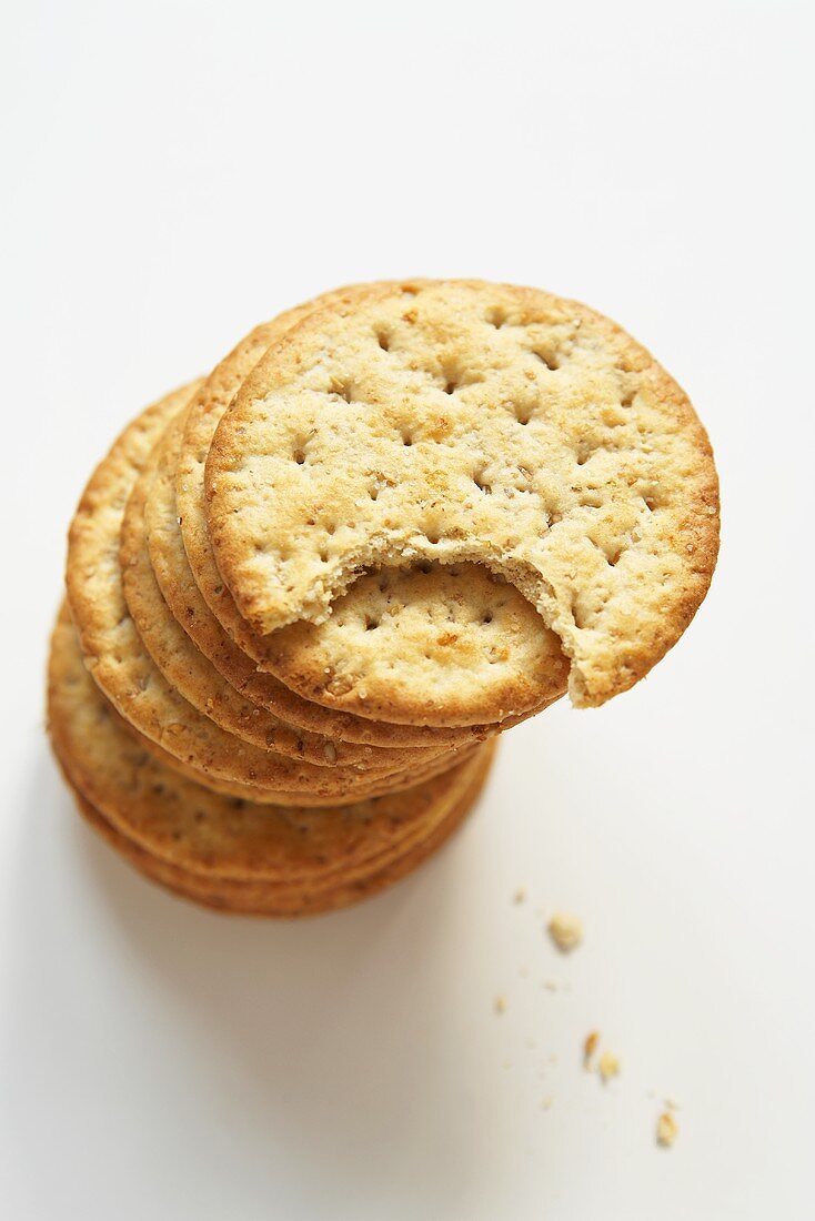 Stack of Round Wheat Crackers; Top Cracker Bitten