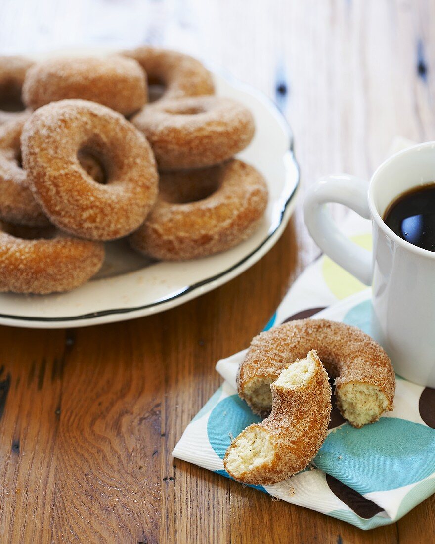 Plate of Sugar Donuts, Halved Donut on Napkin with Coffee