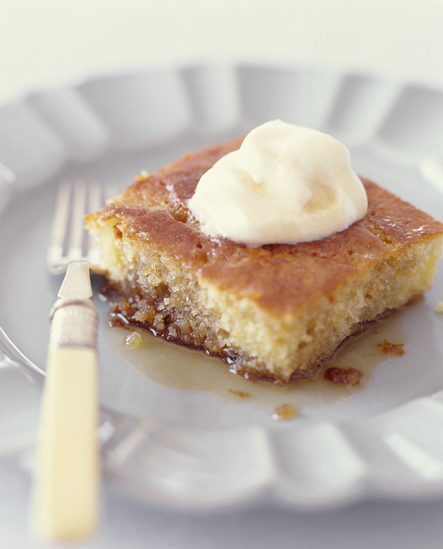 Ein Stück Kuchen mit Ahornsirup und Sahne