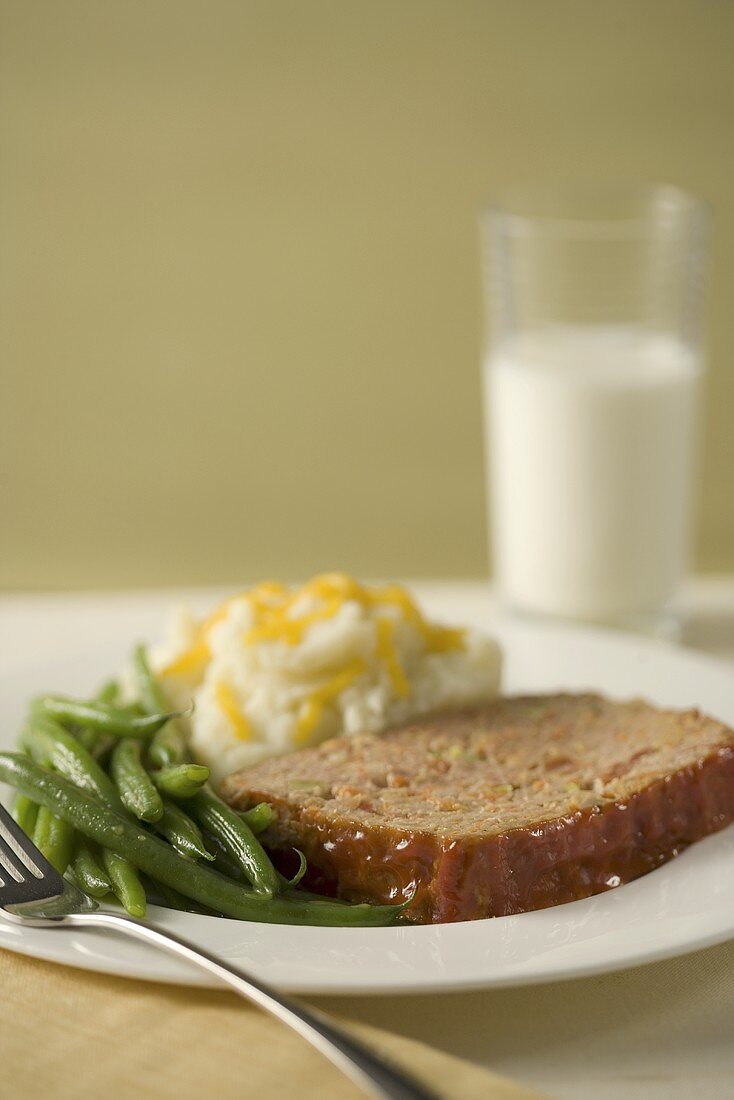 Eine Scheibe Putenhackbraten mit Kartoffelpüree,grünen Bohnen