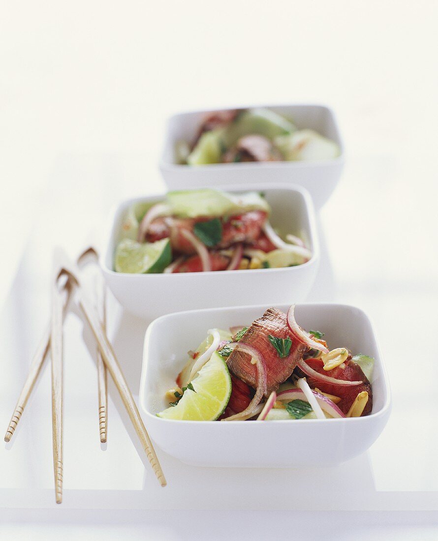 Asiatischer Salat mit Steak-Scheiben in drei Schalen