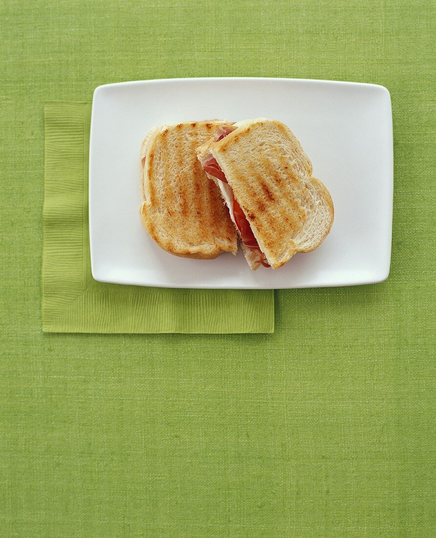 Grilled Ham and Cheese Sandwich; Halved on Plate