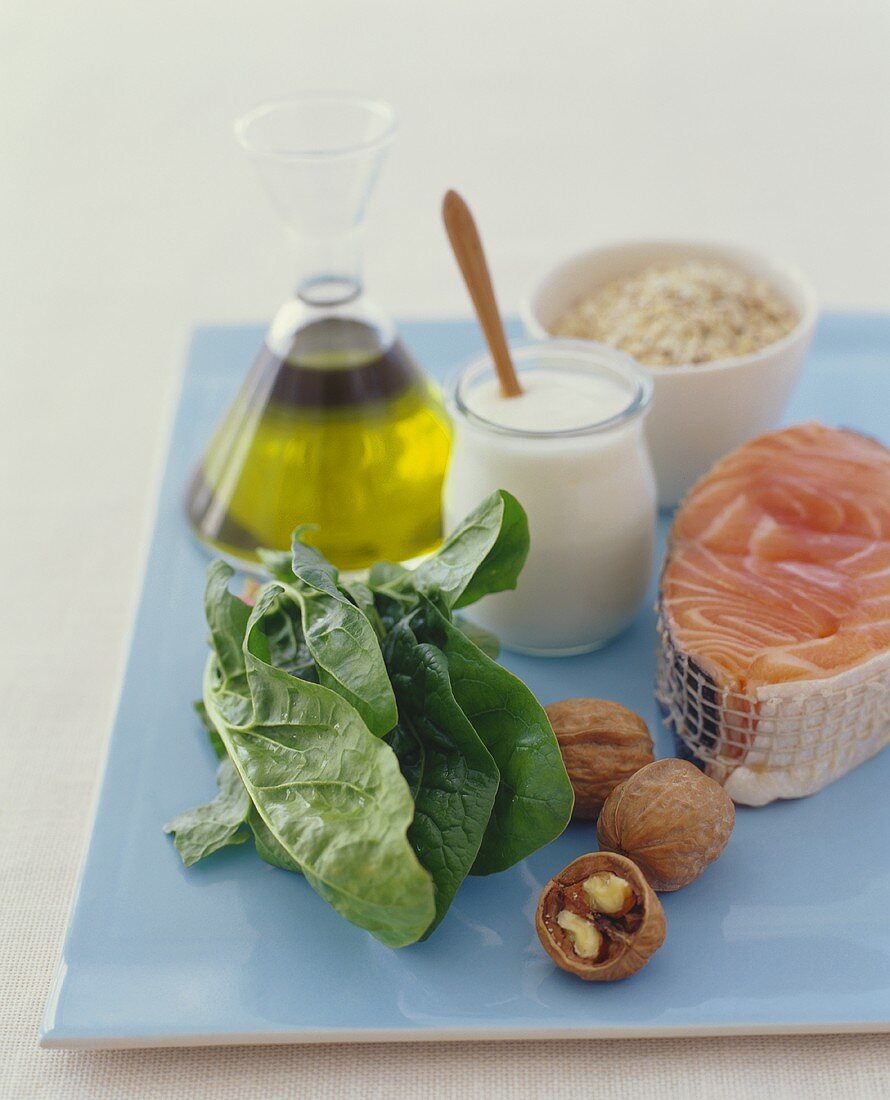 Verschiedene Zutaten (Salatblätter, Lachs, Joghurt, Olivenöl)
