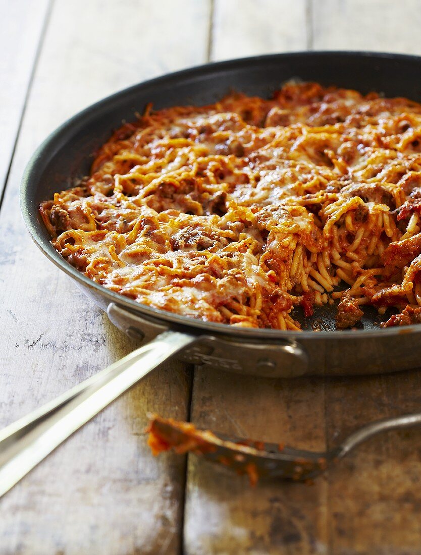 Spaghetti Bolognese in einer Pfanne mit Käse gratiniert