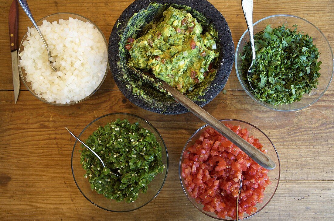 Guacamole mit den einzelnen Zutaten in Schälchen