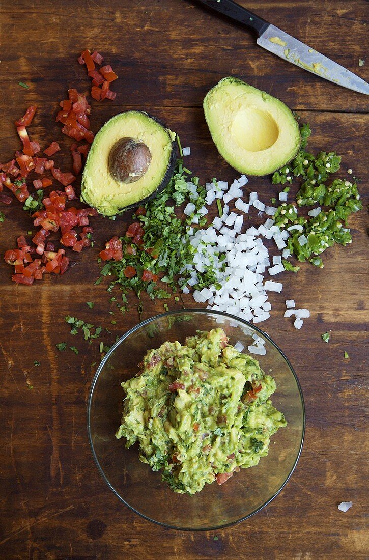 Guacamole in einem Schälchen mit Zutaten